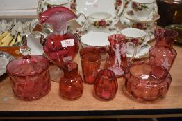 A selection of cranberry glass including hand decorated Mary Gregory style jug and vase