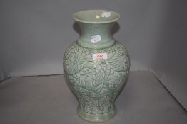A 20th century Bann Celadon Chiangmai vase having embossed decoration of carps and foliage