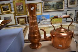 An antique copper stove kettle with a similar copper water jug