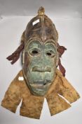 An African tribal ethnic wooden mask having polychrome decoration and fibre dressage possibly Fang