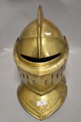 A reproduction medieval knights helmet in brass opens in two parts