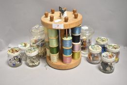 A 20th century cotton bobbin holder with a selection of glass and similar beads