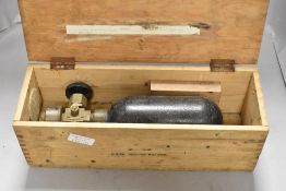 A vintage oxygen tank in wooden case