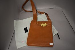 A modern Radley ladies fashion over shoulder tan leather hand bag appears unused with protective