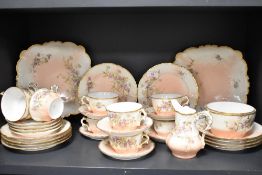 An early 20th century GDA Limoges France part tea service on peach ground with hand decorated floral