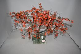 An oriental tree ornament having red stone leaves