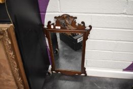 A 20th century Chippendale revival style mirror having shaped frame work with carved eagle