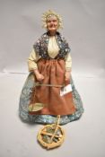 An early 20th century peddler doll having ceramic body with tailored period clothes