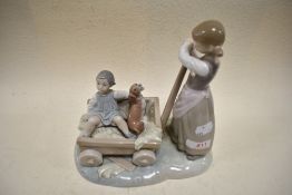 A Lladro figurine, depicting two girls with cart and dog.