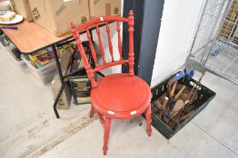 A red painted spindle back chair