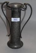 An Art Nouveau pewter vase with Planished finish and shaped handles with flower motifs impressed