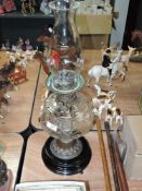 A Victorian oil lamp having cut glass resevoir with brass and ceramic base