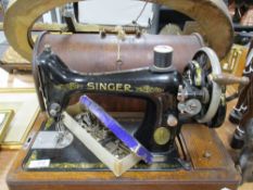A hand cranked Singer Sewing machine with oak case