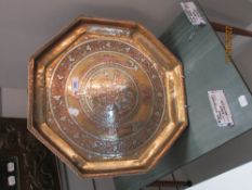 A 20th century octagonal Indian tray inlaid with copper on brass and image of Hindu diety