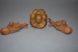 Three wooden carved figures including a pair of Chinese men with carp and a man in ball form