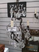 A modern wrought iron and lustre droplet chandelier with two matching wall lights