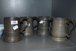 Four antique pewter mugs or tankards in various designs