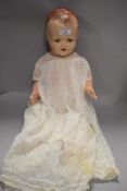 A 20th century composite doll having blue sleeping eyes and christening gown