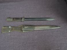 A German Mauser Bayonet 1884-1945 with metal scabbard and leather frog, blade length 25cm, overall