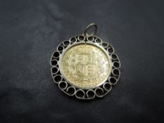 An 1865 shield back, die 15 gold sovereign bearing young head Queen Victoria in a 9ct gold removable