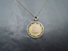 A 9ct gold medalion with engraved decoration and monogram on a yellow metal chain, approx 5.4g