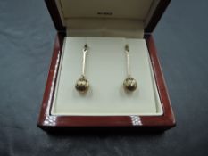 A pair of 9ct gold stud earrings having facetted diamond cut spheres on bar drops, approx 2.4g