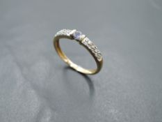 A 9ct gold band ring having small amethyst style stone with diamond chips to shoulders, size L &