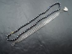 A knotted string of iridescent black cultured pearls with matching stud earrings and a fancy link HM