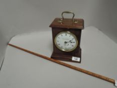 A Knight and Gibbins mahogany cased clock with a vintage yard measure stick