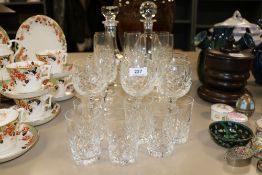 A selection of clear cut crystal glass wares including two decanters, wine glasses and tumblers
