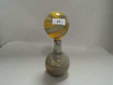 An art glass bottle having large statement stopper.