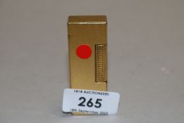 A mid century brass cigarette lighter by Dunhill having machine tooled case