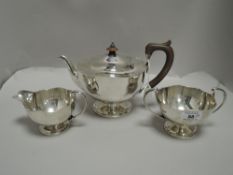 A 1920's three piece silver teaset, of circular form with shaped rims, marks for Sheffield 1922,