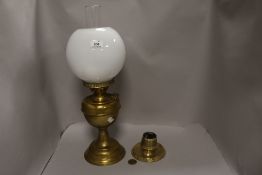 A 20th century brass bodied oil burning lamp with milk glass shade and a vesta striker