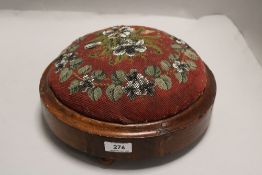 A Victorian button shaped footstool with bead worked top