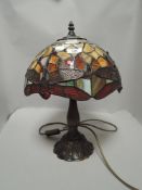 A modern Tiffany style leaded light lamp with dragonfly pattern shade and cast metal base