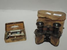 A pair of binoculars radium prismoid with a Gillette Richwood razor set
