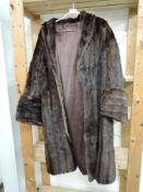A vintage mid length fur coat in dark brown having wide cuffs.