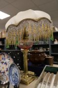 A modern table lamp in an oil light design having brass column support with an Art Deco design