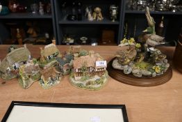 A selection of modern Lilliput lane model houses with a Country Artists Tranquillity figure base