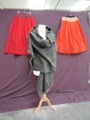 Two early 20th century red wool petticoats having embroidery to hems and a wool shawl with fine