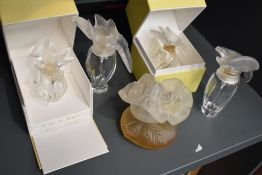 A collection of Nina Ricci perfume bottles, one having partial contents and the others empty, one
