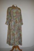 A vintage 1940s printed day dress having buttons to front, long sleeves and side metal zip,