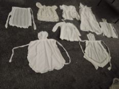 A selection of vintage and antique children's clothing including aprons and dresses, some nice