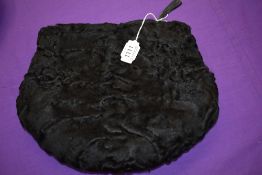 A compact astrakhan Muff, around 1930s, having purse compartment to top with metal zipper.