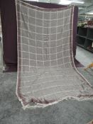 A Victorian crinoline shawl having fringed edges and bright pink, green, blue and red patterns on