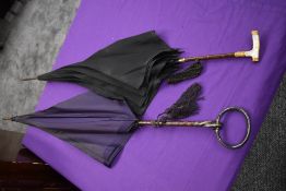 Two antique umbrellas, a purple fabric example having HM silver handle,the other with black with