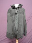 A Victorian grosgrain cape having crepe detail to shoulder and hem with ruffled collar.