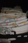 A full box of vintage and antique embroidered table cloths, tray cloths and similar.
