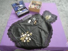An array of buttons, a Victorian black silk apron having floral embroidery and an early 1900s sewing